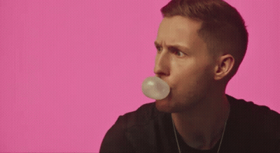 A Man Is Holding A Piece Of Paper In His Mouth . GIF