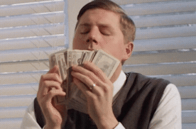 A Man Is Holding A Pile Of Money In His Mouth GIF
