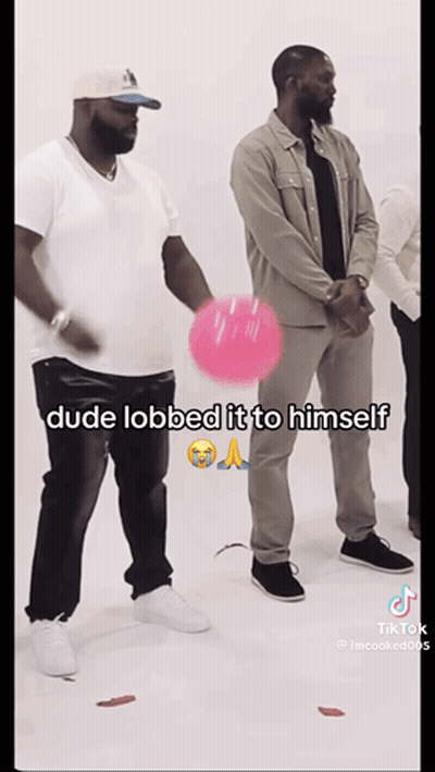 A Man Is Holding A Pink Balloon And Says Dude Lobbed It To Himself On The Bottom GIF