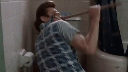 A Man Is Holding A Plunger In His Mouth While Sitting In A Bathroom . GIF