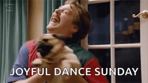 A Man Is Holding A Pug Dog And Laughing . GIF