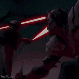 A Man Is Holding A Red Light Saber In A Dark Room GIF