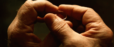 A Man Is Holding A Ring In His Hands GIF