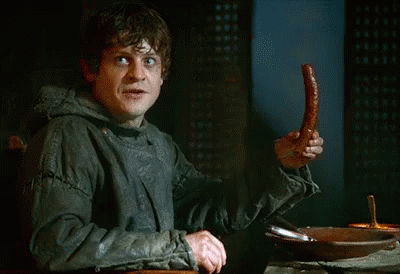 A Man Is Holding A Sausage In His Hand And Making A Funny Face GIF