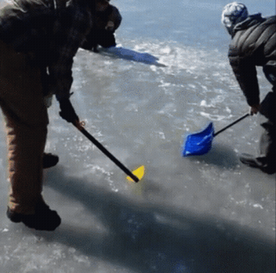 A Man Is Holding A Shovel In The Water GIF