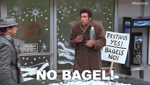 A Man Is Holding A Sign That Says Festivus Yes Bagels No GIF