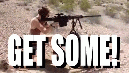 A Man Is Holding A Sniper Rifle In The Desert With The Words `` Get Some '' Behind Him . GIF