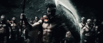 A Man Is Holding A Spear In Front Of A Group Of Spartans . GIF