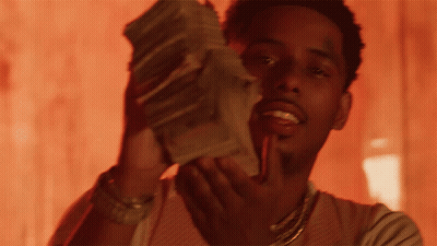 A Man Is Holding A Stack Of Money In His Hands GIF