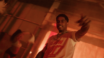 A Man Is Holding A Stack Of Money In His Hands And Wearing A White Shirt With The Number 7 On The Front GIF