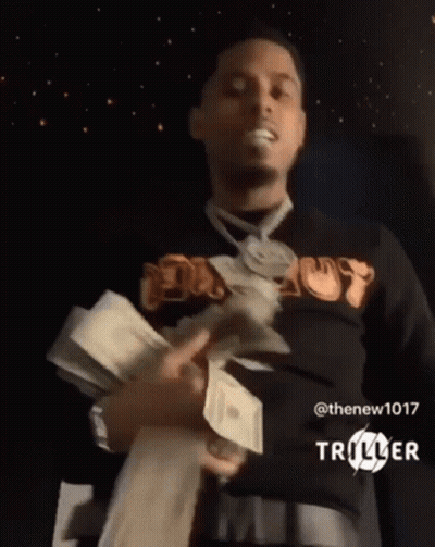 A Man Is Holding A Stack Of Money In His Hands . GIF