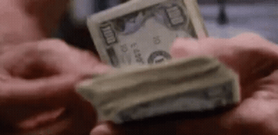 A Man Is Holding A Stack Of Money In His Hands . GIF