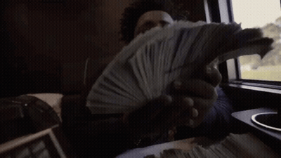 A Man Is Holding A Stack Of Money In His Hands While Sitting In A Car . GIF