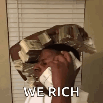 A Man Is Holding A Stack Of Money On His Head And Talking On A Cell Phone . GIF