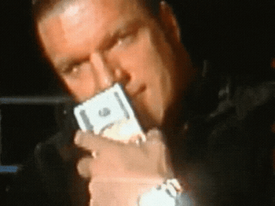 A Man Is Holding A Stack Of Twenty Dollar Bills In His Mouth GIF