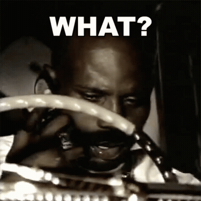 A Man Is Holding A Steering Wheel With The Words What Written On It GIF