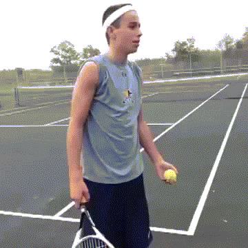 A Man Is Holding A Tennis Ball And A Tennis Racquet On A Tennis Court GIF