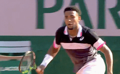 A Man Is Holding A Tennis Racquet In Front Of A Sign That Says Par . GIF