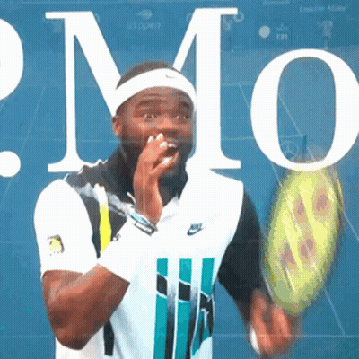 A Man Is Holding A Tennis Racquet In Front Of A Sign That Says Us Open GIF