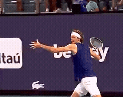 A Man Is Holding A Tennis Racquet In Front Of A Wall That Says Itau GIF