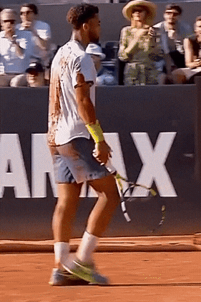 A Man Is Holding A Tennis Racquet On A Court In Front Of A Sign That Says Army GIF