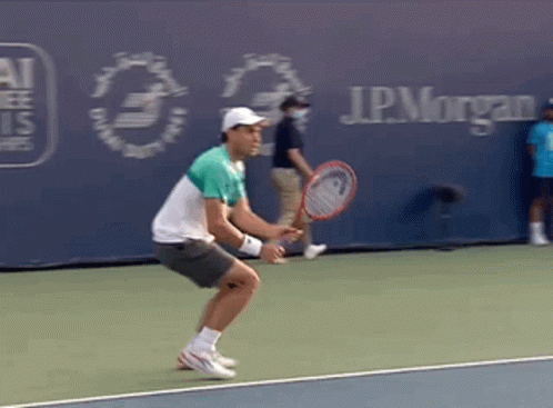 A Man Is Holding A Tennis Racquet On A Tennis Court In Front Of A J.p. Morgan Sign GIF
