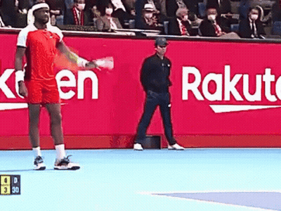 A Man Is Holding A Tennis Racquet On A Tennis Court In Front Of A Rakuten Sign . GIF