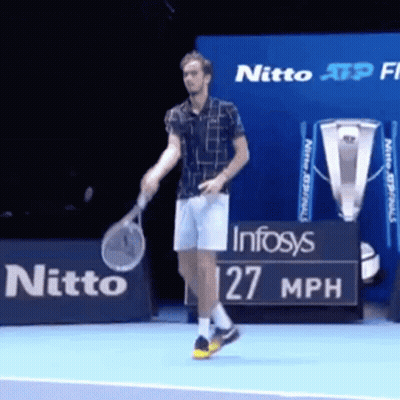 A Man Is Holding A Tennis Racquet On A Tennis Court In Front Of A Sign That Says Nitto GIF
