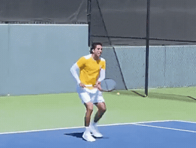 A Man Is Holding A Tennis Racquet On A Tennis Court GIF