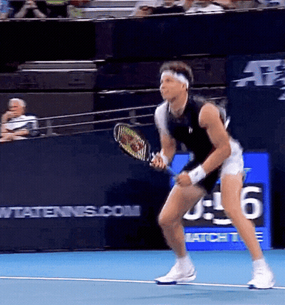A Man Is Holding A Tennis Racquet On A Tennis Court With A Sign That Says Wtatennis.com In The Background GIF