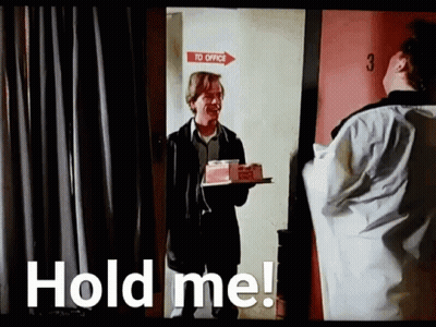 A Man Is Holding A Tray With A Cake On It In Front Of A Door . GIF