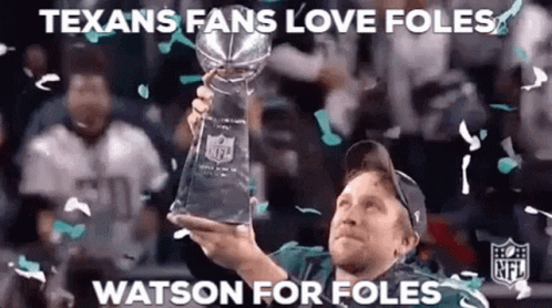 A Man Is Holding A Trophy In His Hand While Confetti Falls Around Him . GIF