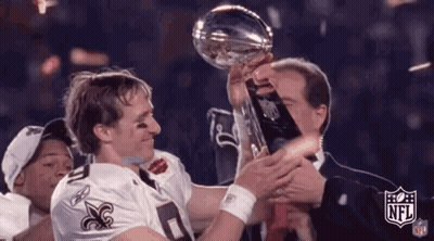 A Man Is Holding A Trophy In His Hands While A Man In A Suit Holds A Trophy . GIF