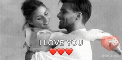 A Man Is Holding A Woman In His Arms With The Words `` I Love You '' Written On It . GIF