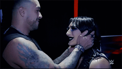 A Man Is Holding A Woman 'S Face With A W Logo In The Background GIF