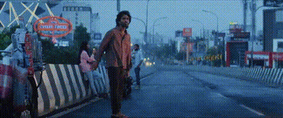 A Man Is Holding A Woman 'S Hand While Standing On The Side Of A Street . GIF