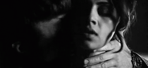 A Man Is Holding A Woman 'S Neck And Kissing Her In A Black And White Photo . GIF
