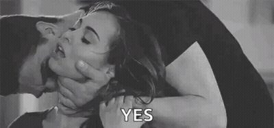 A Man Is Holding A Woman 'S Neck While Kissing Her . GIF