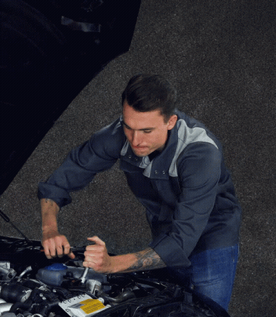 A Man Is Holding A Wrench In Front Of A Car With The Hood Open GIF