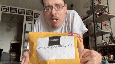 A Man Is Holding An Envelope That Says " We Love You Ricky < 3 " GIF
