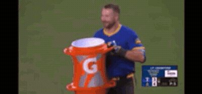 A Man Is Holding An Orange Gatorade Container GIF