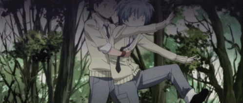 A Man Is Holding Another Man In A Forest GIF