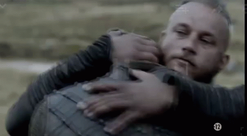 A Man Is Holding Another Man In His Arms While They Are Fighting . GIF