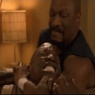 A Man Is Holding Another Man 'S Head In His Arms . GIF