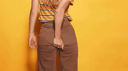 A Man Is Holding His Butt In Front Of A Yellow Background With The Words What Ever Written On It GIF