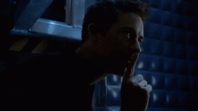 A Man Is Holding His Finger To His Mouth And Making A Silence Gesture . GIF
