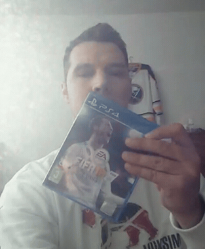 A Man Is Holding Up A Fifa 18 Video Game For Ps4 GIF