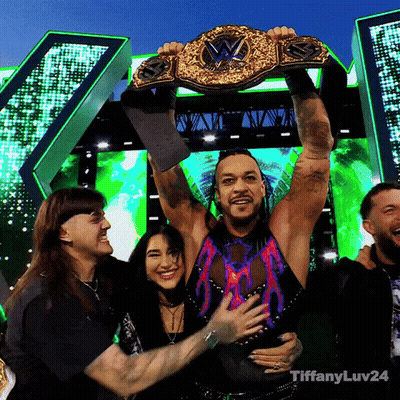 A Man Is Holding Up A Wrestling Championship Belt With Tiffanyluv24 Written Below Him GIF