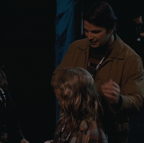 A Man Is Hugging A Little Girl With A Lanyard That Says Lady Raven On It GIF