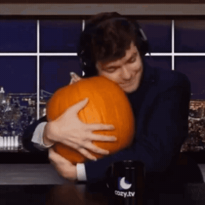A Man Is Hugging A Pumpkin In Front Of A Cozy Tv Mug . GIF
